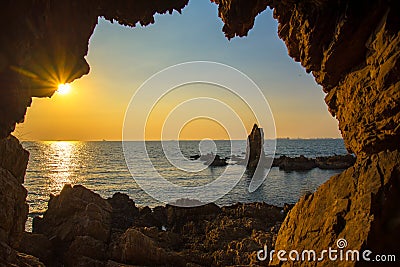 The cave near the sea on the sunset Stock Photo