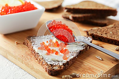 Caviar, bread, lemons and cutting board on light background Stock Photo