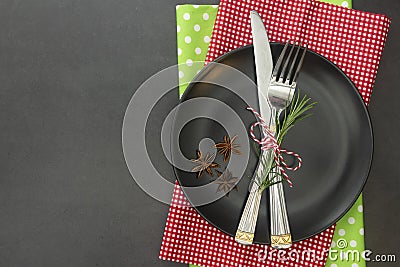 cChristmas place setting with ribbon. Black plate with fork and knife, decorated. Top view, copy space Stock Photo