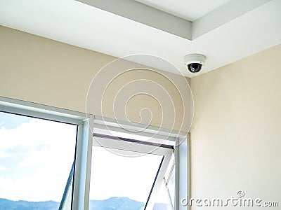 CCTV system security. Round CCTV camera on ceiling in the corner of the walkway in condominium Stock Photo