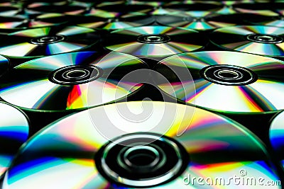 CDs / DVDs lying on a black background with colorful reflections of light. Stock Photo