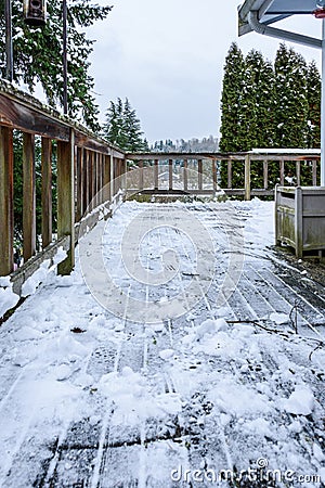 Cedar deck after snow shoveled off, stormy snow day Stock Photo