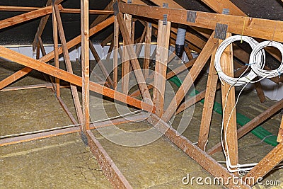 Ceiling and attic floor insulation made of rock wool between the trusses, visible ends of plastic pipes from ventilation. Stock Photo