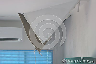 The ceiling is broken, the gypsum board is damaged. Dropped out of the ceiling The house is damaged on the ceiling. The ceiling Stock Photo