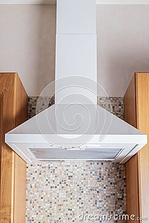 Ceiling metal white cooker hood above the kitchen stove. Modern kitchen appliances Stock Photo