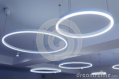 Ceiling with round modern LED lamps. Suspended fluorescent lights under the ceiling. Careful energy consumption, energy saving Stock Photo