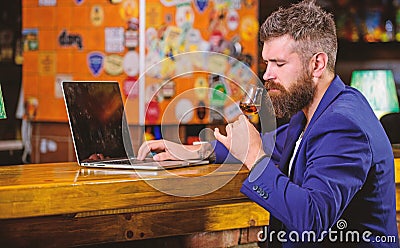Celebrate success. Businessman internet surfing drink alcohol. Man bearded businessman bar counter laptop cognac Stock Photo