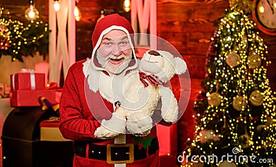 Celebrating christmas. winter season. holiday shopping online. cheerful santa man hold toys. bear for all. bearded man Stock Photo