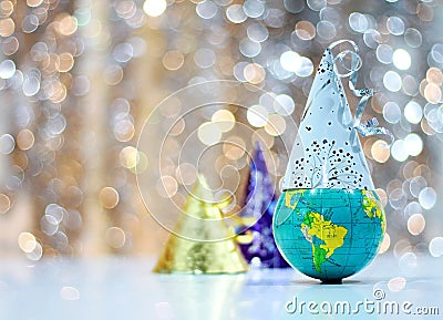 Celebrating New Years with a globe and party hats representing world wide celebrations Stock Photo