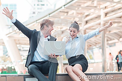 Celebrating success.Excited cheerful young business couple keeping arms raised and expressing positivity as they know the succes Stock Photo