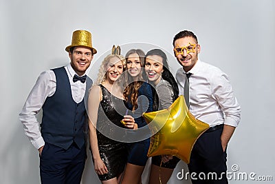 Happy friends with golden party props posing Stock Photo