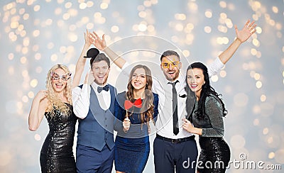 Happy friends with party props posing over lights Stock Photo