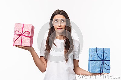 Celebration, holidays and presents concept. Waist-up portrait of cute, dreamy young girl wondering what gift box is Stock Photo