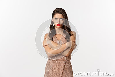 Celebration and party concept. Sulking woman looking angry, dressed for formal event in glamour dress, hugging herself Stock Photo