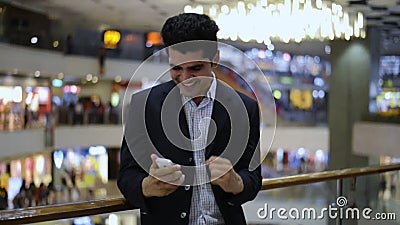 Celebrazione dell'uomo d'affari il suo successo mentre esaminando un telefono cellulare video d archivio Celebrazione dell'uomo d'affari il suo successo mentre esaminando un telefono cellulare video d archivio