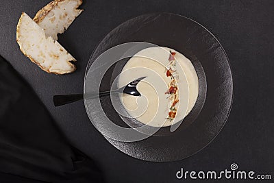 Celery cream soup in black plate over dark background from above Stock Photo
