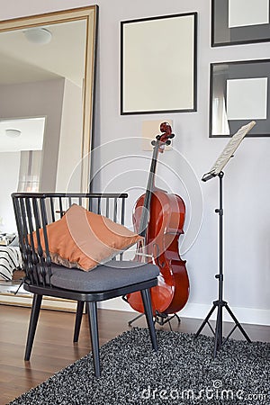 Cello or violoncello musical instrument with wooden chair and pillow Stock Photo