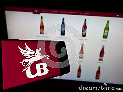 Cellphone with logo of company United Breweries Holdings Limited (UBHL) on screen in front of website. Editorial Stock Photo