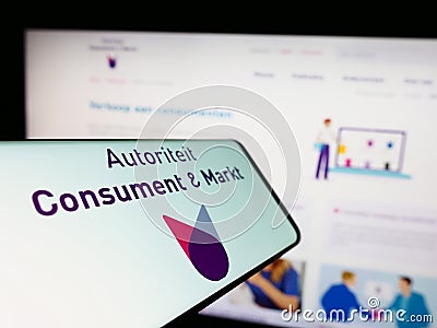 Cellphone with logo of Dutch regulator Autoriteit Consument en Markt (ACM) on screen in front of website. Editorial Stock Photo