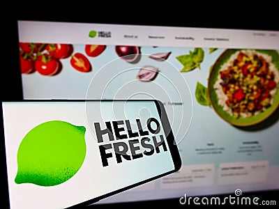 Cellphone with logo of German meal-kit company HelloFresh SE on screen in front of business website. Editorial Stock Photo