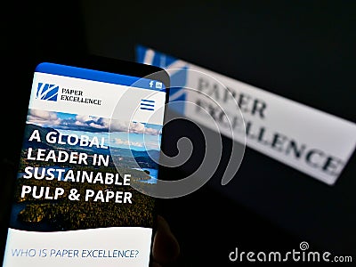 Cellphone with web page of Canadian paper and pulp manufacturer Paper Excellence B.V. on screen in front of logo. Editorial Stock Photo