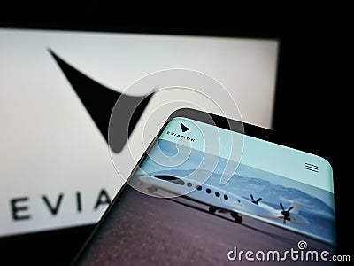 Cellphone with webpage of electric aircraft company Eviation Aircraft Ltd. on screen in front of business logo. Editorial Stock Photo