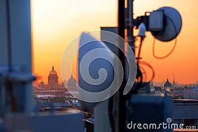 Cellular antennas on the roofs at sunset Stock Photo