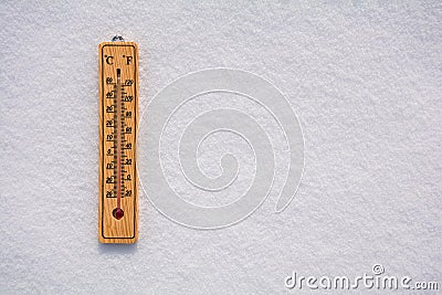 Celsius and Fahrenheit thermometer on the surface of white pure snow. Copy space Stock Photo