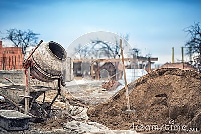 Cement mixer machine at construction site, tools and sand Stock Photo