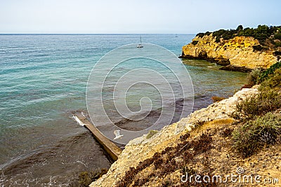 cement pier at Praia dos TremoÃ§os or lupines at ArmaÃ§Ã£o de Pera Stock Photo