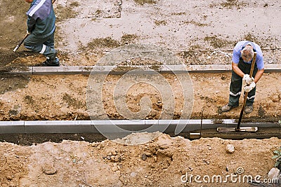 Cement tamping worker. paving Editorial Stock Photo