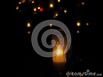 Burning white and colourful candles on a cemetery at night of all the saints, orange lights. Stock Photo