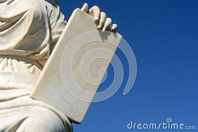 Robed person holding stone tablet Stock Photo