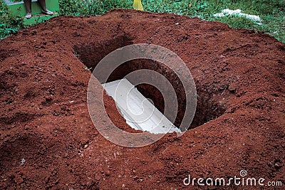 Cemetery, White coffin in grave hole before burried Stock Photo