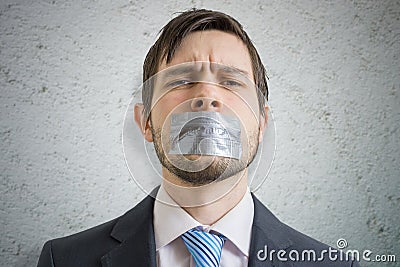 Censorship concept. Young man is silenced with duct tape over his mouth Stock Photo