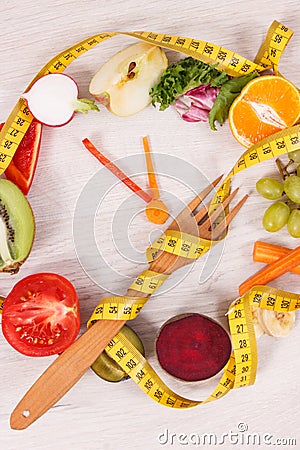 Tape measue with fruits and vegetables in shape of clock showing time to healthy eating and slimming Stock Photo