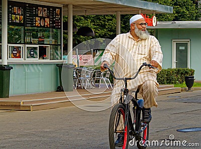 Central Asian elderly man rides a bicycle Editorial Stock Photo