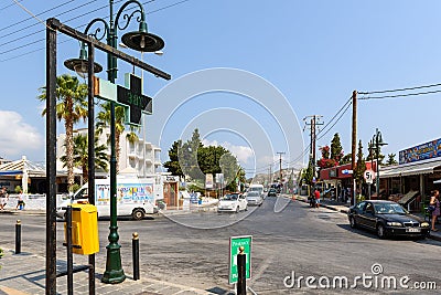 Central crossroads with thermometer, showing hot weather temperature, in pharmacy sign in Faliraki town. Rhodes island, Greece Editorial Stock Photo
