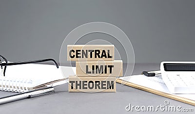 CENTRAL LIMIT THEOREM text on wooden block with notebook,chart and calculator, grey background Stock Photo