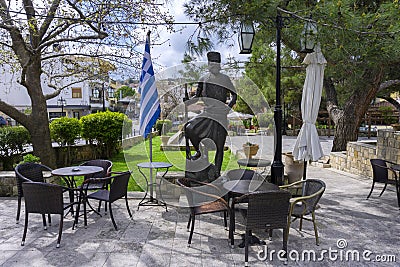 Central Square of Archanes village with the traditional coffee shops. Bronze statue of a cretan hero Stock Photo