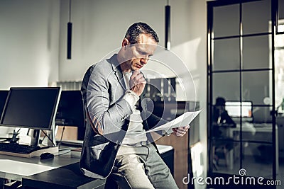 CEO of the company feeling thoughtful while reading the documents Stock Photo