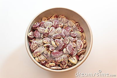 Ceramic bowl of red speckled October beans, centered, isolated on white Stock Photo