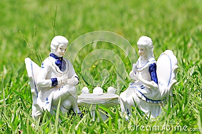 Ceramic couple having tea in a the garden Stock Photo