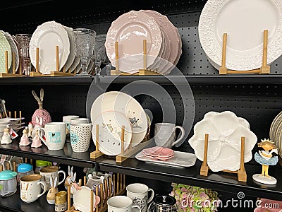 Ceramic plates and cups, on the black shelf of the store. Editorial Stock Photo