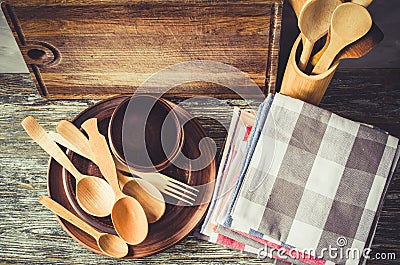 Ceramic plates, wooden or bamboo cutlery, vintage cutting board and towels in interior of kitchen Stock Photo