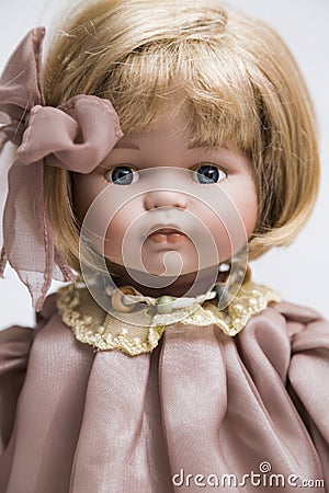 Ceramic porcelain handmade doll with blond hair and pink dress Stock Photo