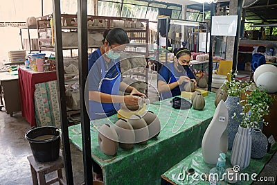 A ceramic potter is carving a pattern on the ceramic gelatin. Editorial Stock Photo