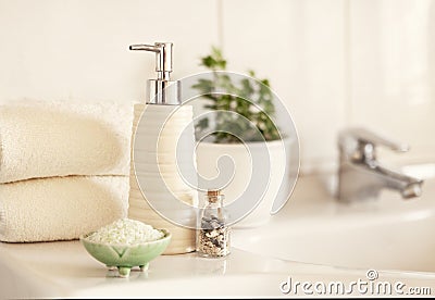 Ceramic soap, shampoo bottle, bowl with bath salt and white cotton towels on Blurred bathroom interior background with sink and Stock Photo