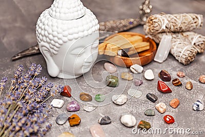 Ceramic statuette of a Buddha head. Selection of semiprecious stones. Stock Photo