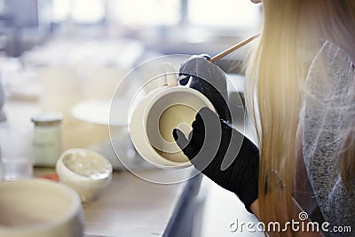 Ceramic studio process, women close-up coloration and glazing a cu Stock Photo